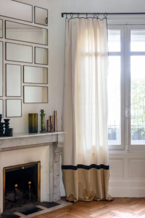 Rideau beige doré en velours et coton suspendu à une fenêtre de salon