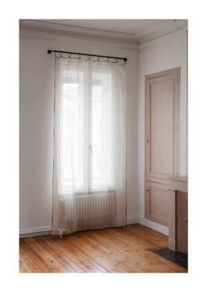 Rideau voilage beige léger devant une fenêtre, lumière naturelle tamisée